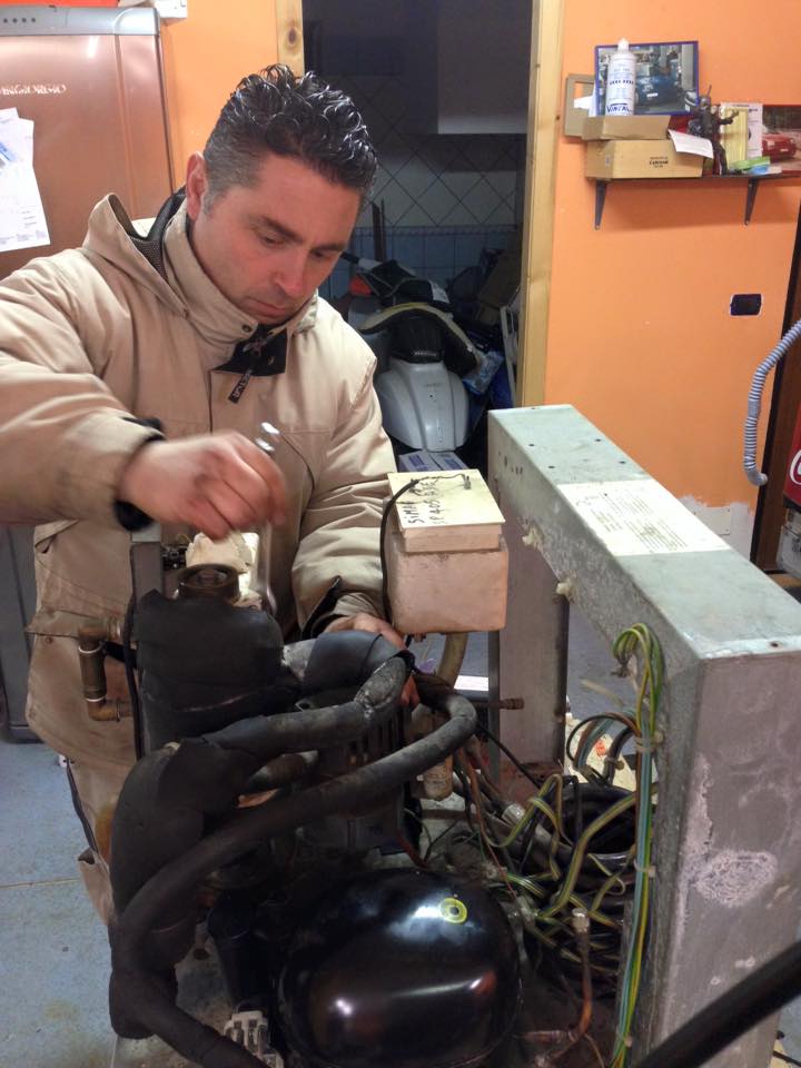 Tecnico frigorista al lavoro su compressore frigorifero a Roma